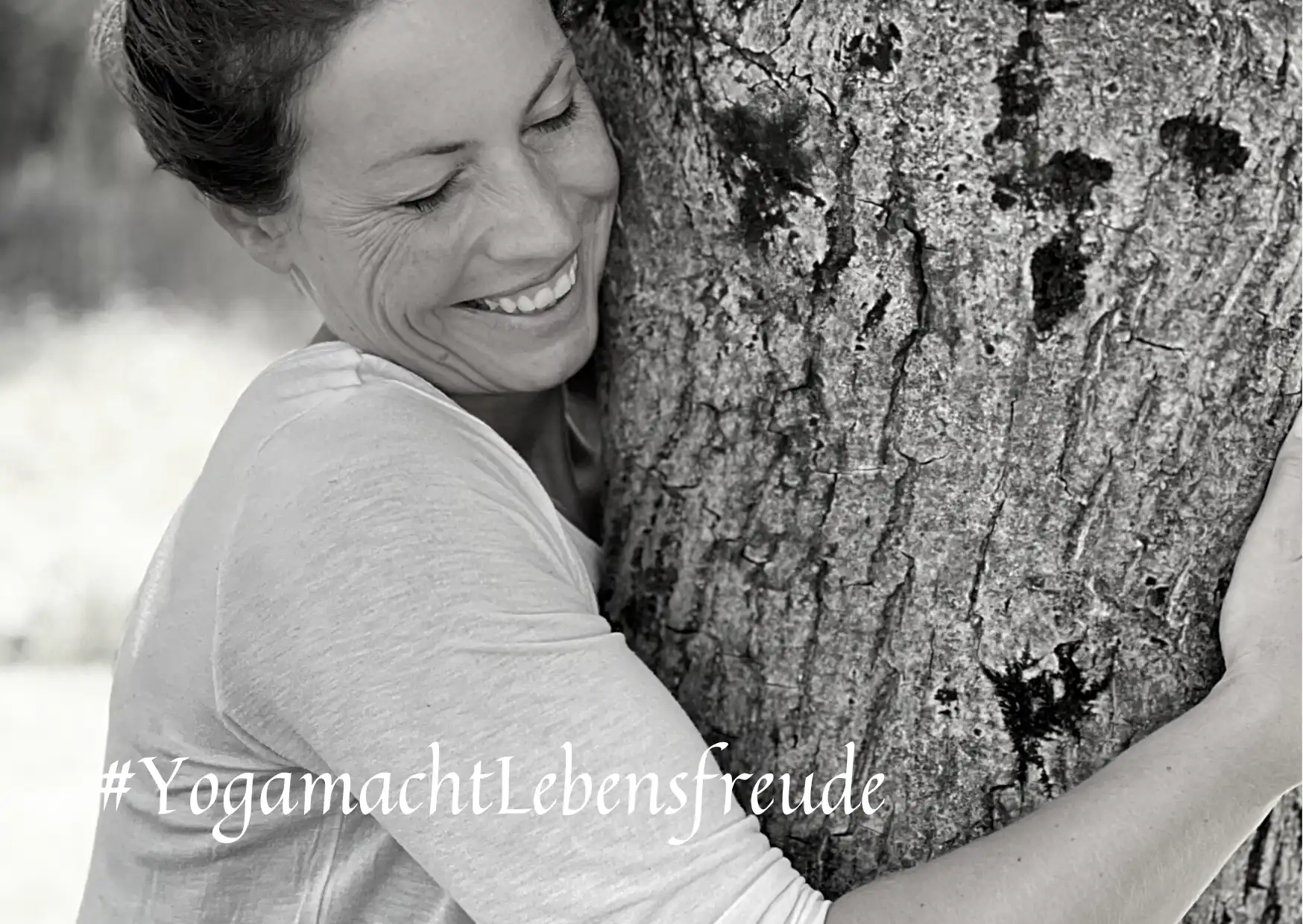 Tanja Happacher umarmt einen Baum in der Natur und lächelt – Yoga für mich, Achtsamkeit und Verbindung zur Natur.